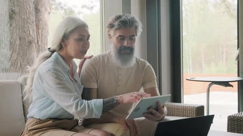 Couple Using a Tablet Together on Sofa