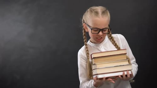 Young Girl Holding Books in School Uniform