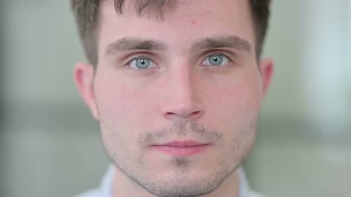 Nahaufnahme eines jungen Mannes, der in die Kamera schaut