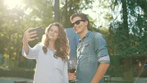 Smiling Couple Taking Selfie Outdoors in Sunlight