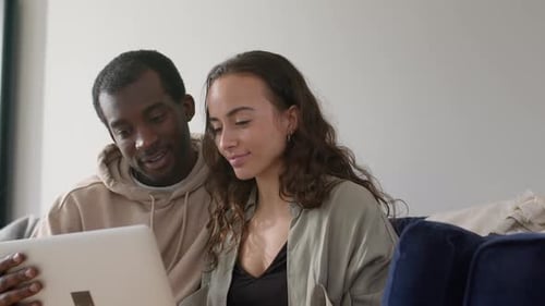 Joyful Couple Watching a Laptop Together on Couch
