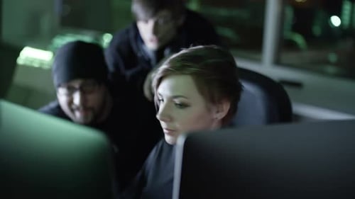 Team of Hackers Working at Computers at Night