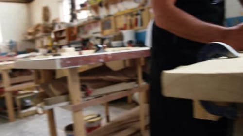 Man Working with Wood in Carpentry Workshop