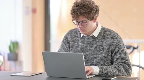 Young Adult with Laptop Gives Thumbs Up