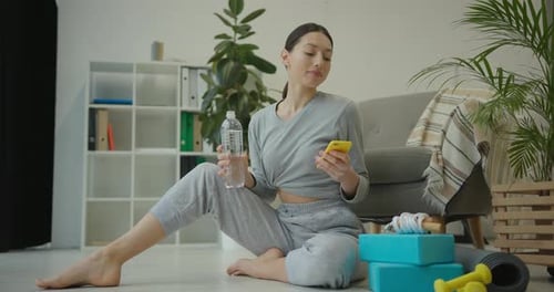 Woman Using Phone After Workout at Home