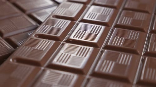 Chocholate blocks in a row fine glazed texture 4K 3840X2160 30fps UltraHD video - Slow tilt over dar