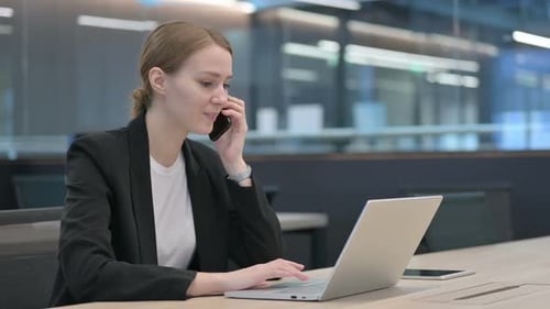 Professional Woman Working with Laptop and Talking Phone
