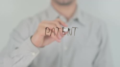 Hand Writes 'Patent' on Transparent Surface