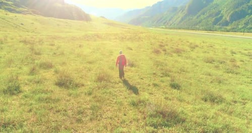 Flight Over Backpack Hiking Tourist Walking Across Green Mountain Field