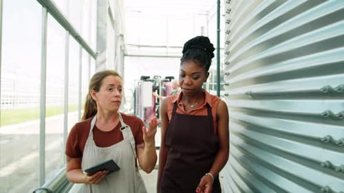 Agriculture: Two Women Talking in an Indoor Greenhouse