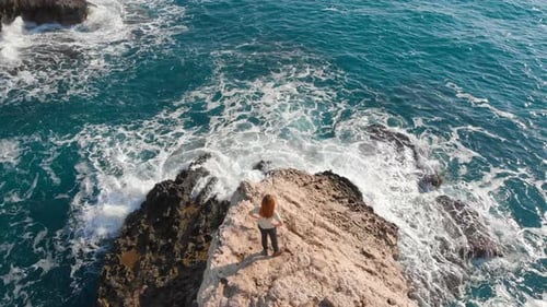 Aerial View of Sea Waves Break on Stone Beach and Girl