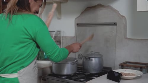 Woman Cooks and Drums on Kitchen Pots