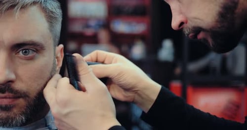 Barber Trims Man's Hair with Electric Trimmer