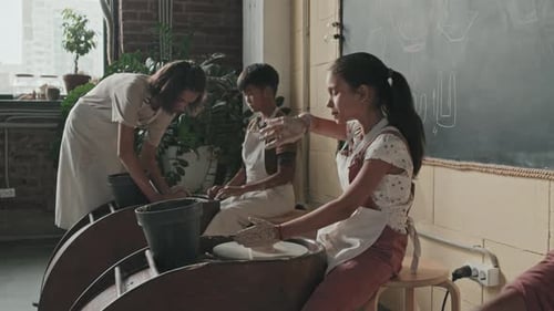 Children Learning Pottery Art in Studio with Instructor