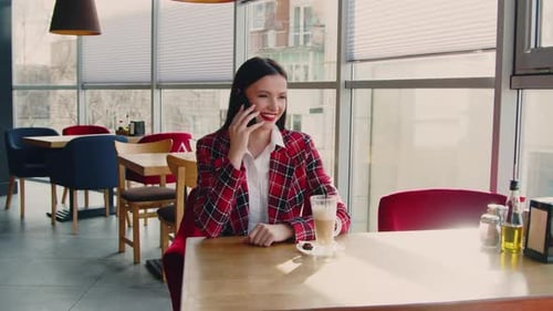 Woman Talking on Phone in Modern Cafe