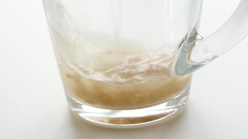 De l'eau ajoutée au thé granulé dans un verre (vidéo au ralenti)