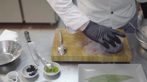 Chef in Black Rubber Gloves Finishing To Prepare Dish with Raw Tuna and Salmon in Modern Restaurant