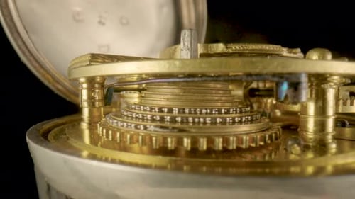 Inside View of a Moving Clockwork of Golden Mechanical Clock on Black Isolated Studio Background