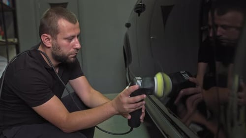 Man Polishing a Car with Electric Polisher