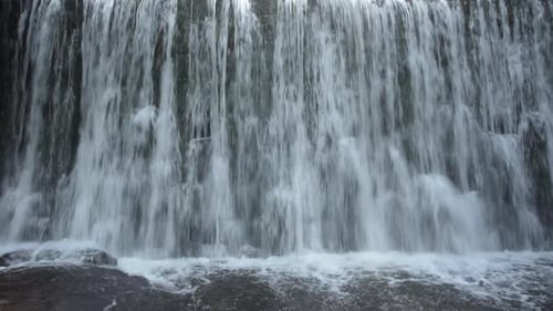 Refreshing Waterfall Flowing Over Rocks in Nature