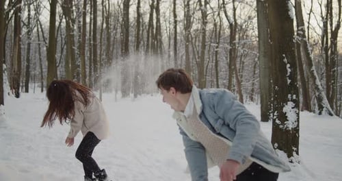 Happy Young Beautiful Couple Have Fun in Sunny Winter Forest Together