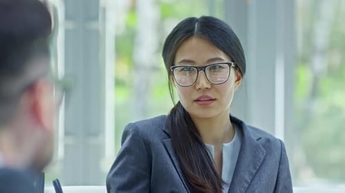 Concentrated Asian Businesswoman Listening Colleague