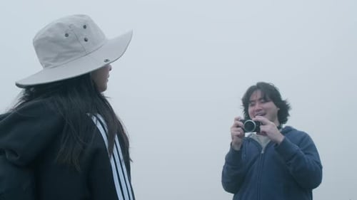 Couples of Asian tourists enjoy taking photos on top of the mountain.
