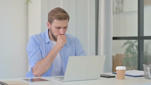 Man Coughs While Working at His Computer