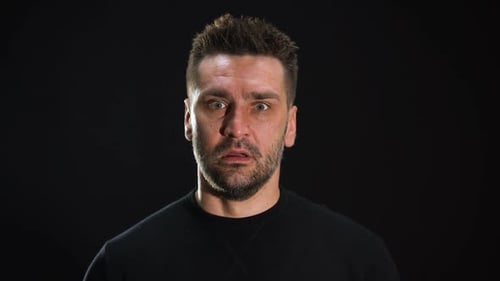 Man Registers Shock and Puts Hands to Forehead