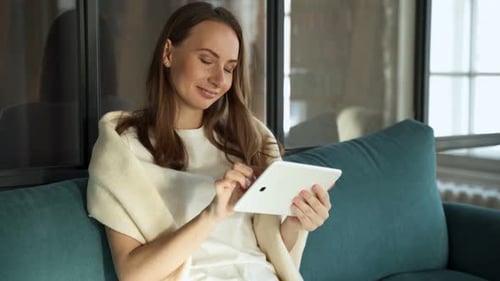 Woman Using Tablet on Sofa Indoors