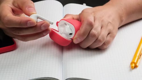 Hands Removing Wireless Earbuds From Case