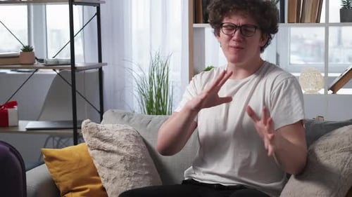 Young Adult Reacting Emotionally at Home on Couch