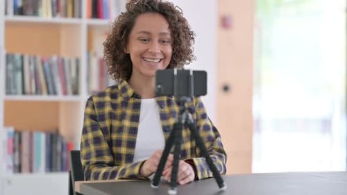 Smiling Woman Talking Into a Phone on Tripod