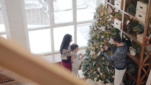 Family Decorates Christmas Tree in Bright Home