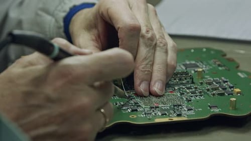 Close up of manual soldering of a large circuit board