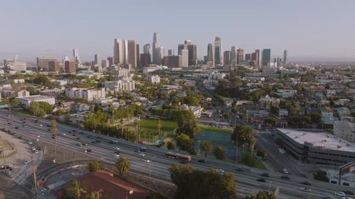 Aerial Drone Shot of Downtown Los Angeles Skyline, Busy Freeway Below on Sunny Day