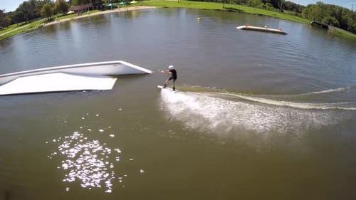 Foto Zumbido de un hombre montado en una tabla de wakeboard en un parque de cables.