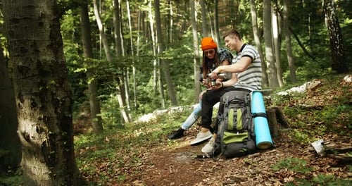 Couple Relaxing in Forest During Hike