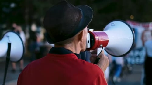 Man Speaks Into Megaphone at Nighttime Protest