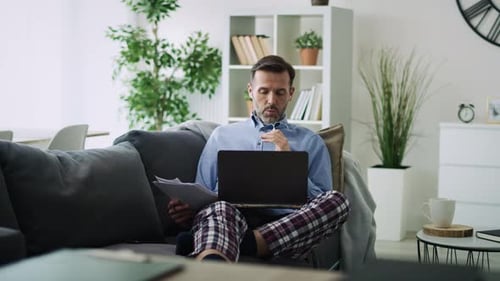Man Working on Laptop From Home on Sofa