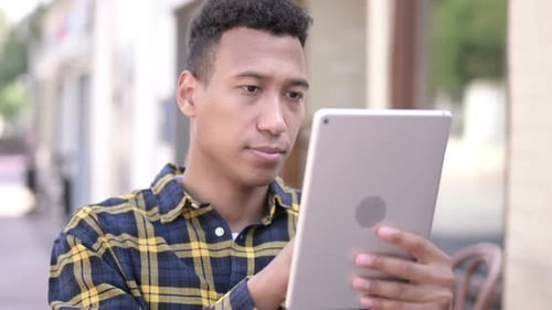 Young Adult Using Tablet in City Setting