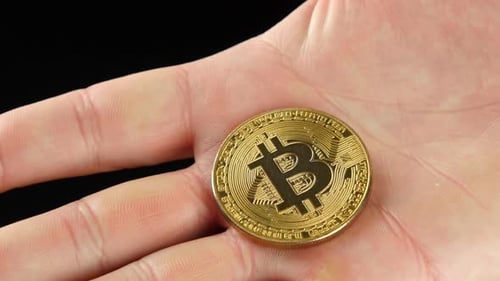 Hand Displaying a Single Bitcoin Currency