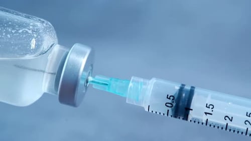 Syringe Extracting Liquid from Vial Close Up