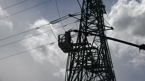 Worker on Electrical Tower Working on Power Lines