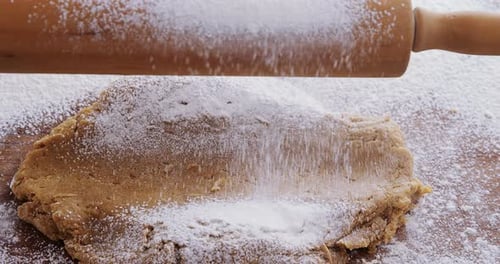 Flour Being Sprinkled on Dough with Rolling Pin