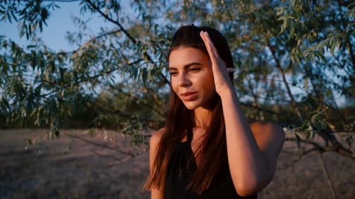 Elegant Woman Posing near a Tree at Sunset