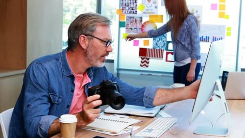 Man Reviews Photos at Creative Office Workspace