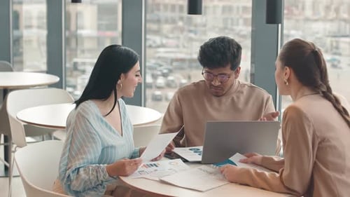 Colleagues Discussing Business Documents in Restaurant