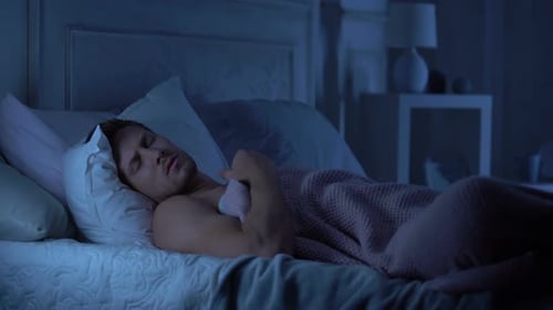 Young Man Sleeping Peacefully in Bed at Night