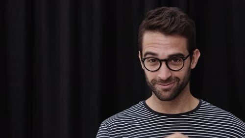 Bearded Man Adjusting Glasses and Smiling Portrait